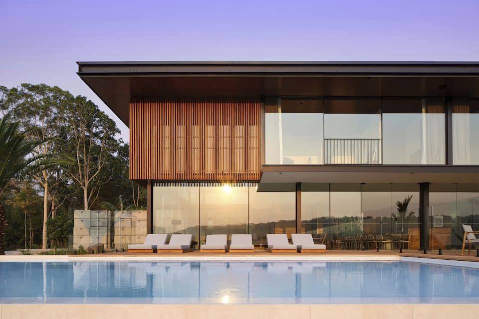 Exterior of wood paneled home with pool