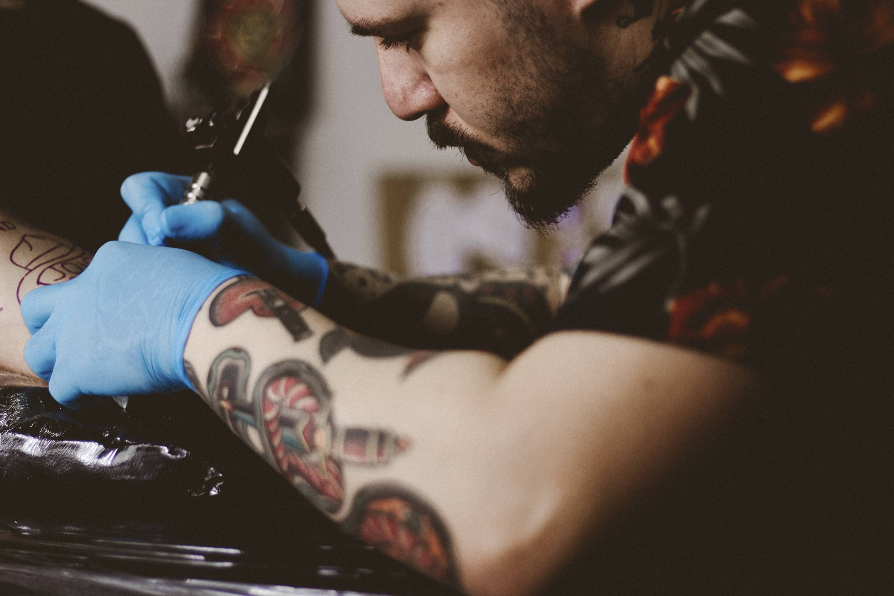 Tattoo artist inks client.